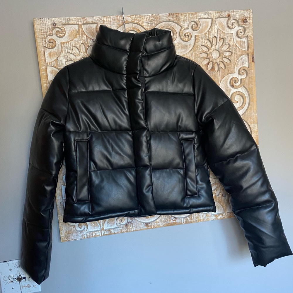 Black faux leathery puffer coat. Never worn!!